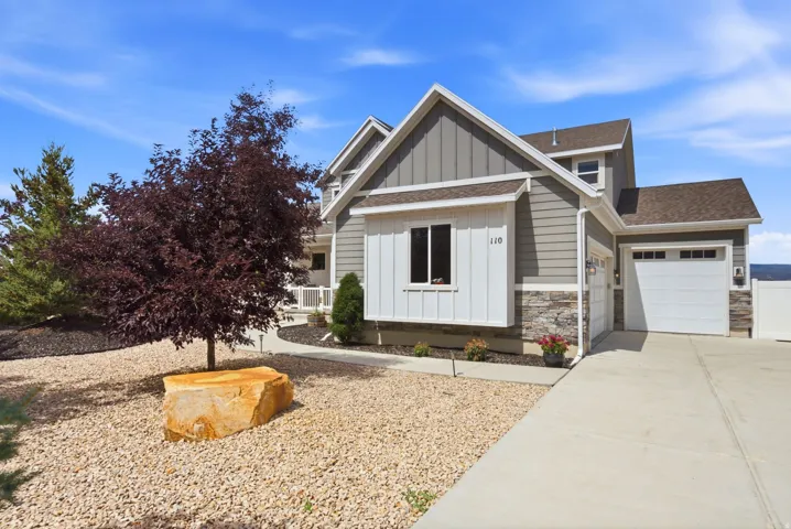 Exterior with gray siding, white vertical siding accents, stone veneer detailing, and a two-car garage