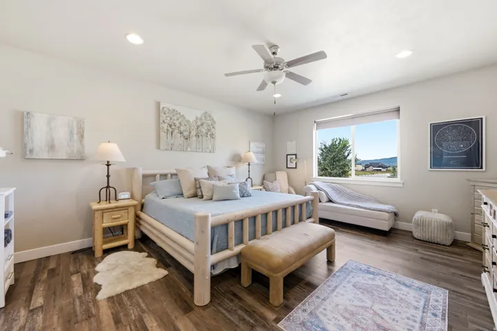 Recessed lighting, ceiling fan, expansive window, wood-finish flooring, and light wall tones