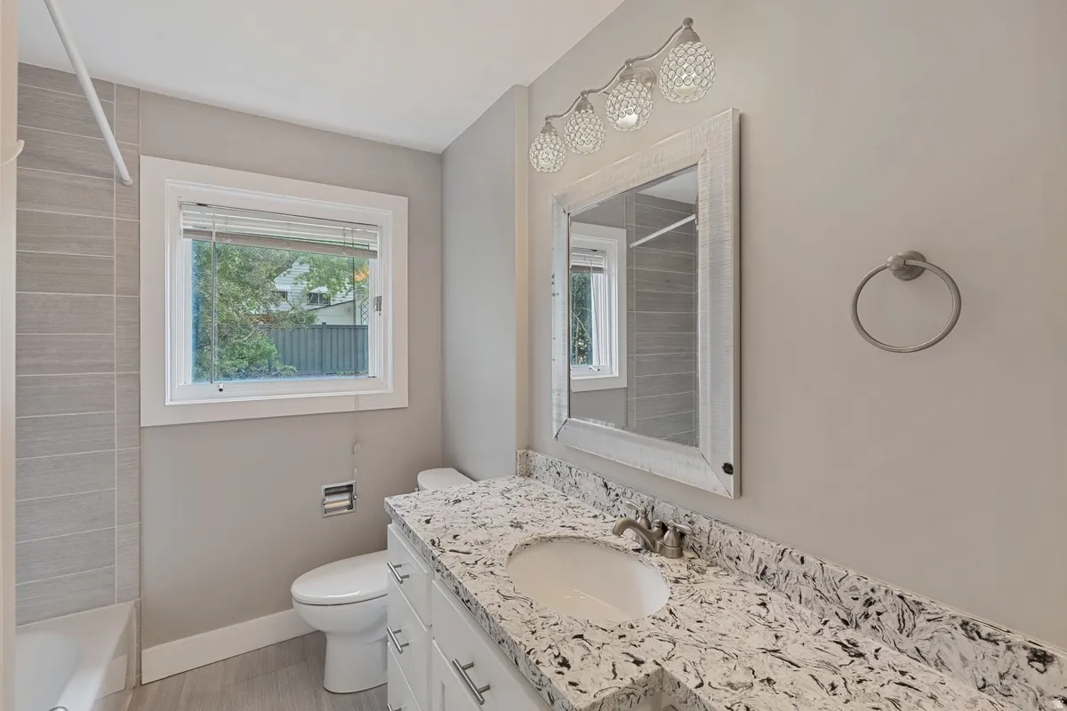 Vanity with an integrated sink, patterned countertop, and chrome faucet