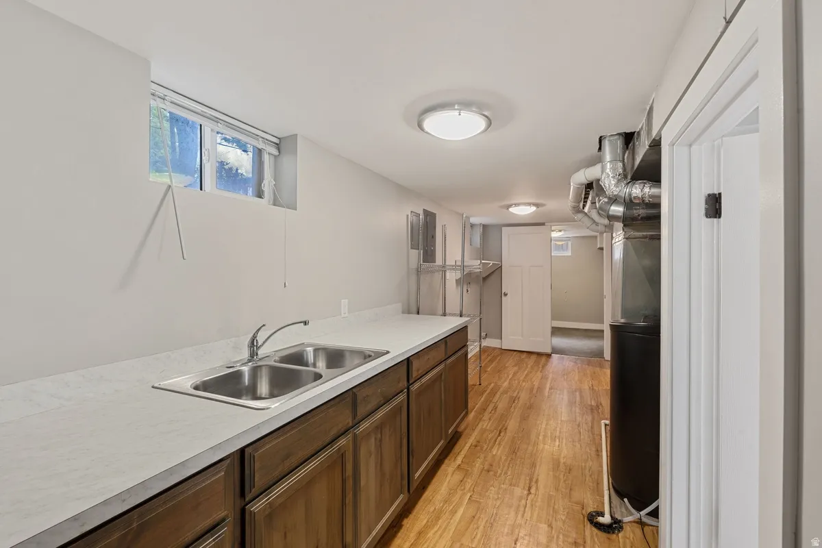 Wood-finish flooring, recessed lighting, and a double-basin stainless steel sink with ample countertop space