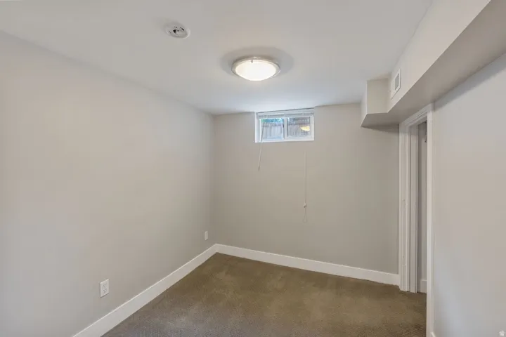 Room featuring light gray painted walls, brown carpet flooring, and a white trim