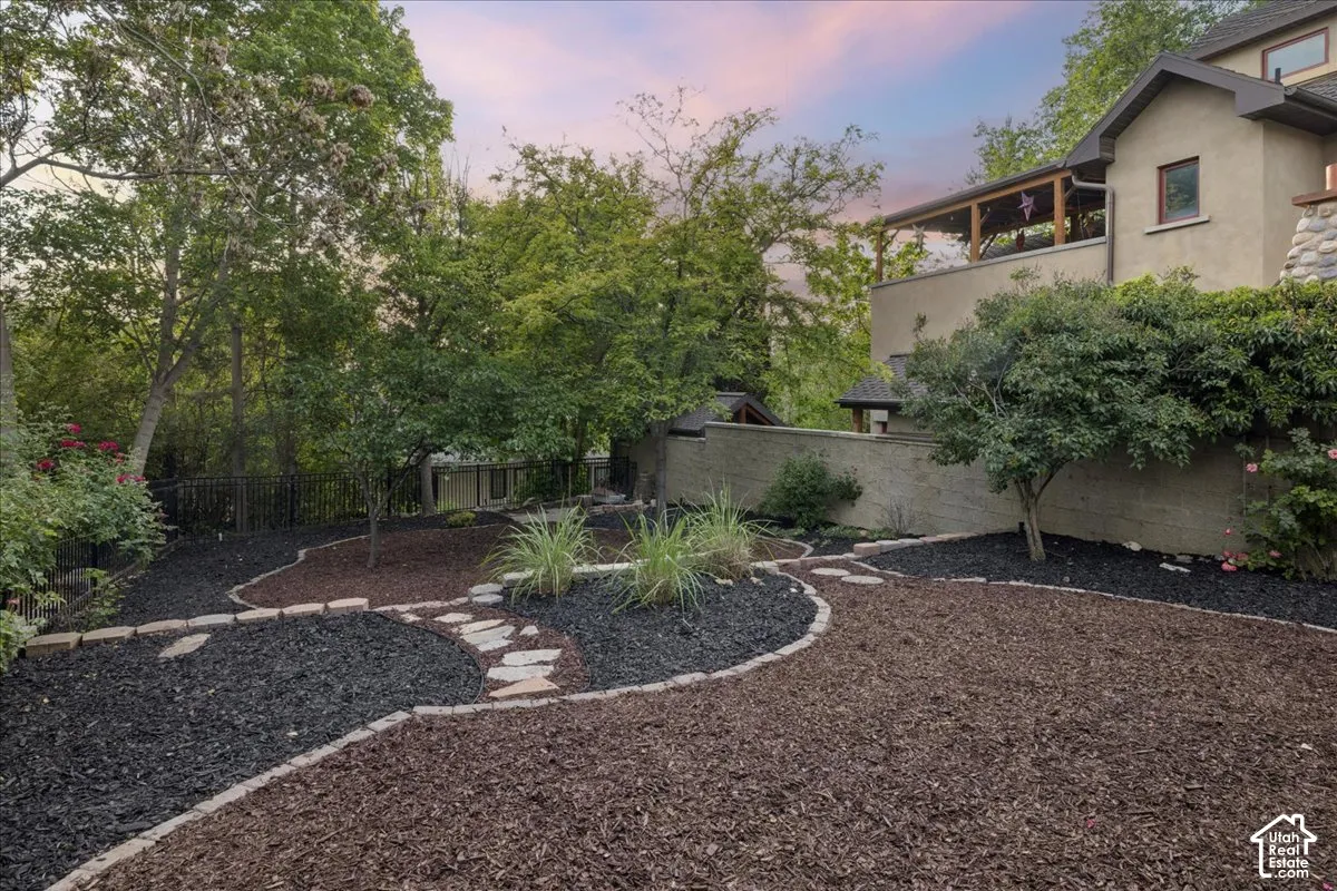Landscaped backyard featuring layered mulch beds in dark and brown tones