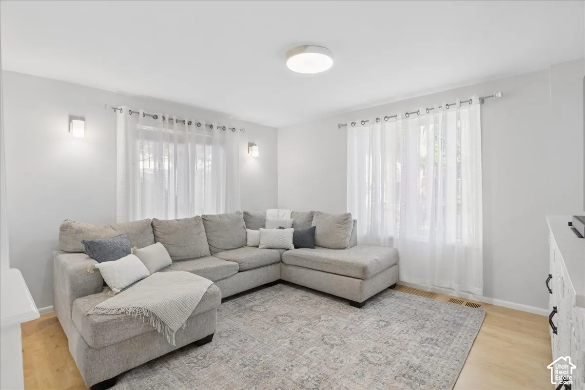 Recessed lighting, wood-finish flooring, and white walls