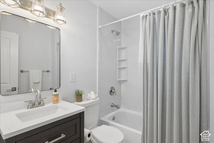 Bathroom featuring a dark wood-finish vanity with a white countertop, an undermount sink, and a brushed nickel faucet