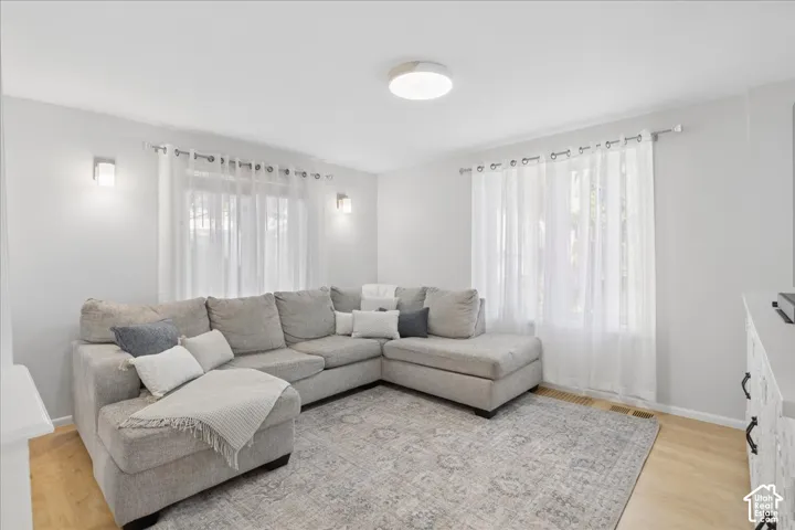 Recessed lighting, wood-finish flooring, and white walls