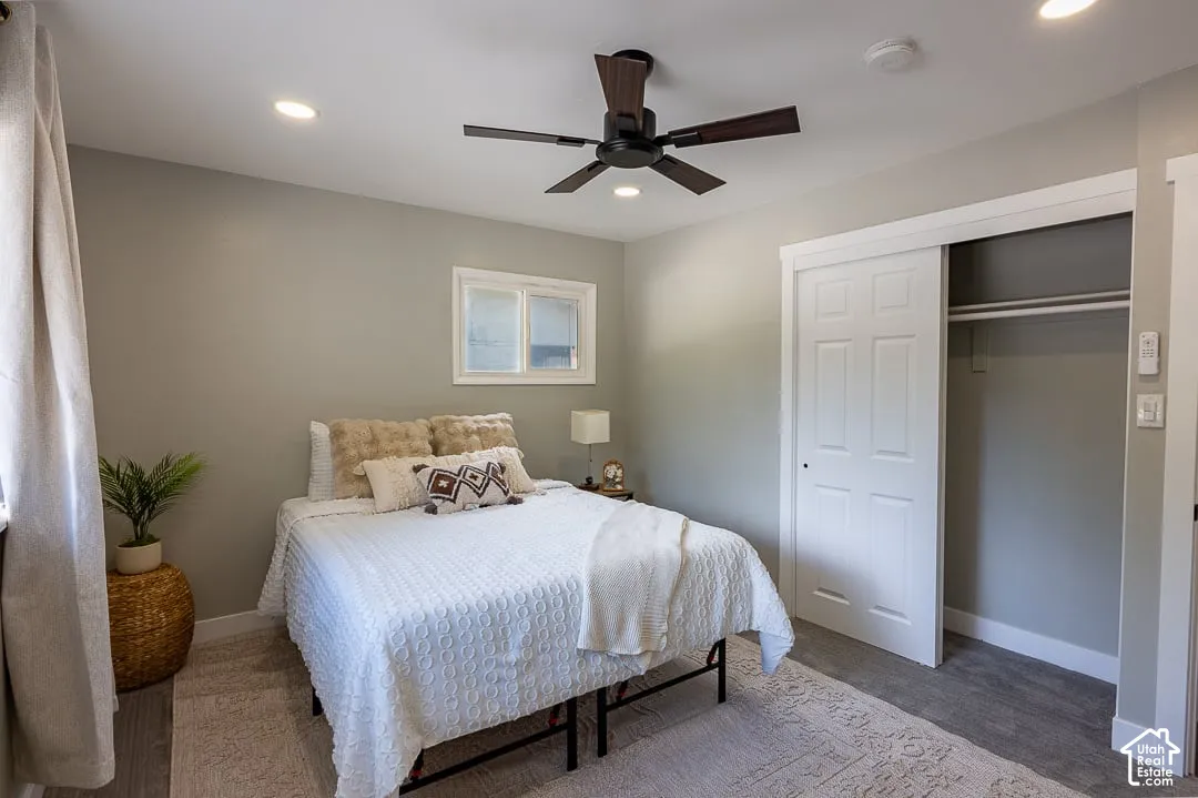 Recessed lighting, wood-finish flooring, ceiling fan, sliding closet doors, and a window with trim