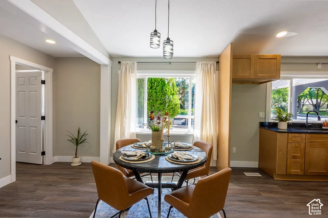 Wood-finish flooring, recessed lighting, and a modern kitchen with natural wood cabinetry and a dark countertop