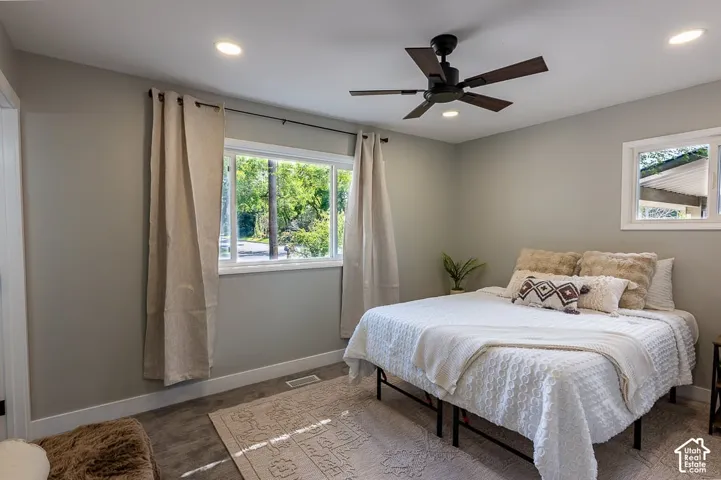 Recessed lighting, wood-finish flooring, white window frames, and a ceiling fan