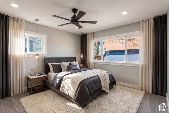 Recessed lighting, ceiling fan, two windows, wood-finish flooring, and a built-in wall sconce