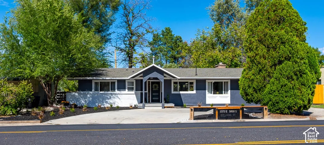 Contemporary exterior with a covered entry, dark siding, and contrasting white trim