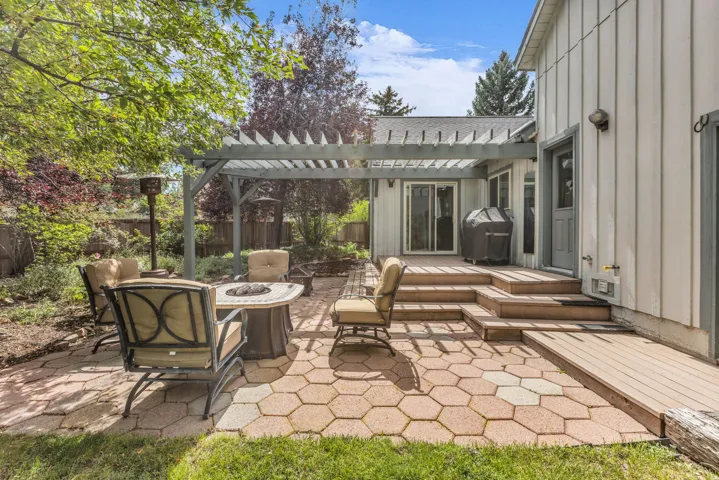 Paved patio with hexagonal pavers, wood pergola, and multi-level composite deck