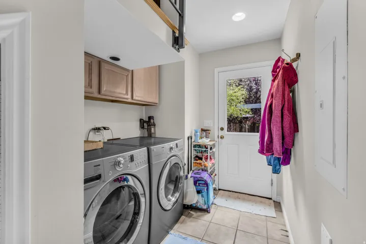 Laundry area featuring upper cabinetry, recessed lighting, and tile flooring