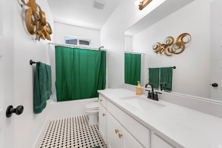 White vanity with quartz countertop, undermount sink, and matte black faucet