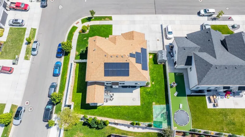 Residential property with a tan shingle roof and solar panels