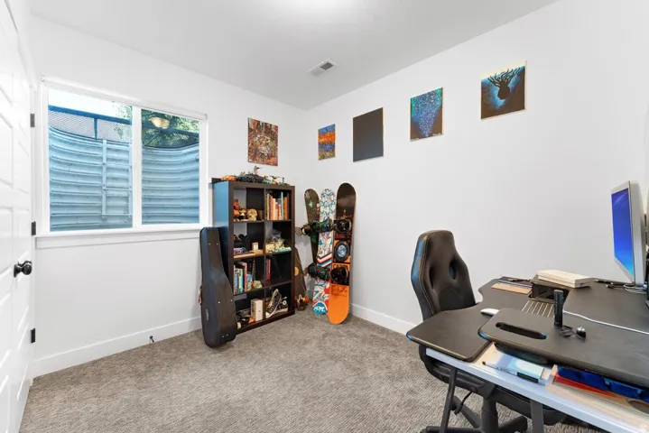 Carpeted room featuring a white door, large window, and recessed lighting
