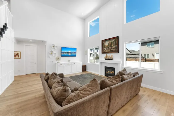 Vaulted ceiling with multiple windows, light wood-finish flooring, built-in fireplace, and custom built-in cabinetry