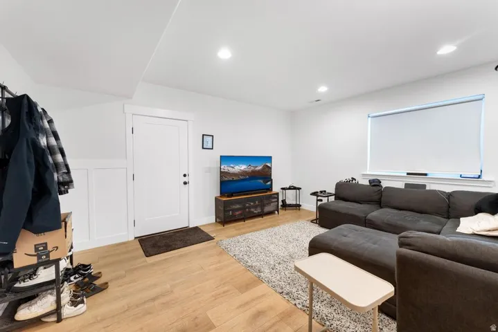 Recessed lighting, wood-finish flooring, and white wall paneling