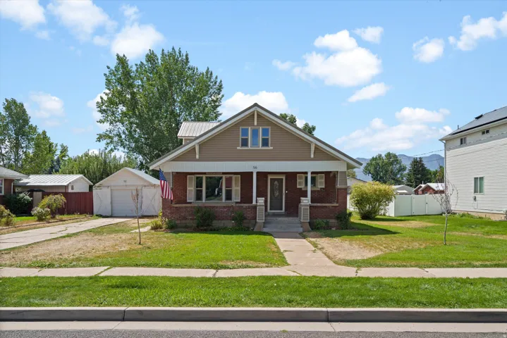 Brick and siding exterior with a covered front porch featuring white pillars