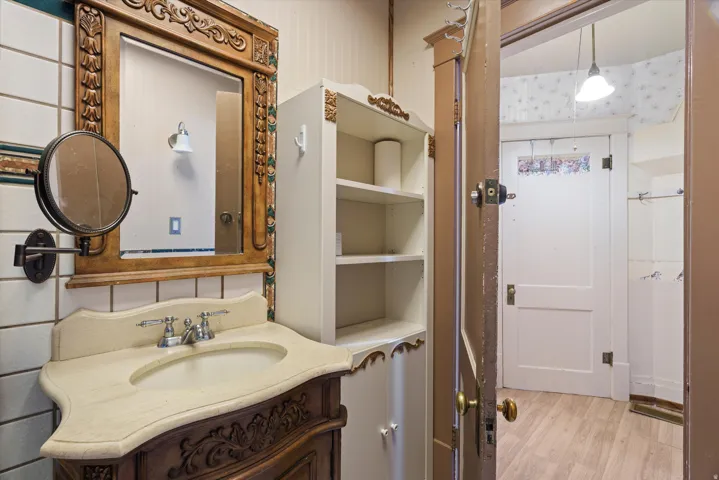 Ornate carved wood vanity with an integrated sink and classic faucet