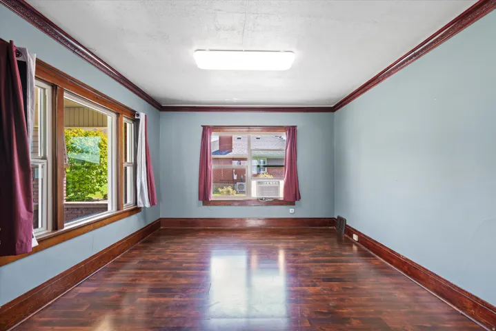 Wood-finish flooring, light blue walls, and dark wood trim