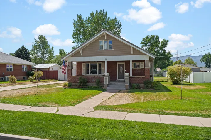 Brick and siding exterior with a covered front porch and a gabled roofline