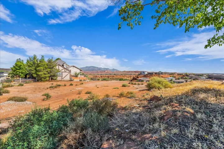 Expansive undeveloped lot featuring natural desert vegetation and distant mountain ranges