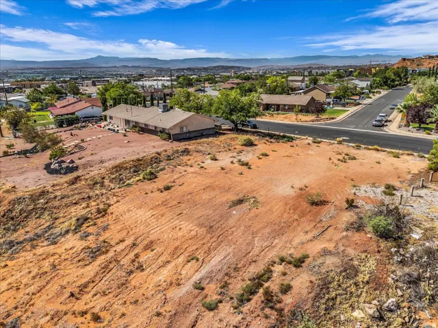 Expansive undeveloped land featuring a desert landscape with natural rock formations and distant mountain scenery