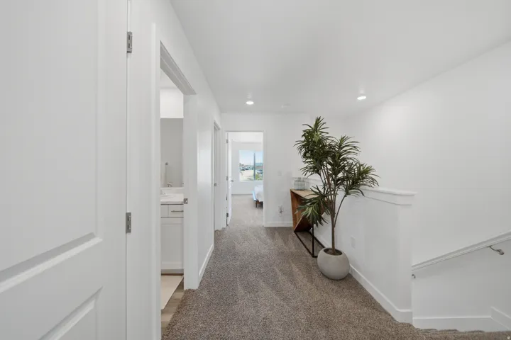 Hallway with gray carpet flooring, white walls, and recessed lighting