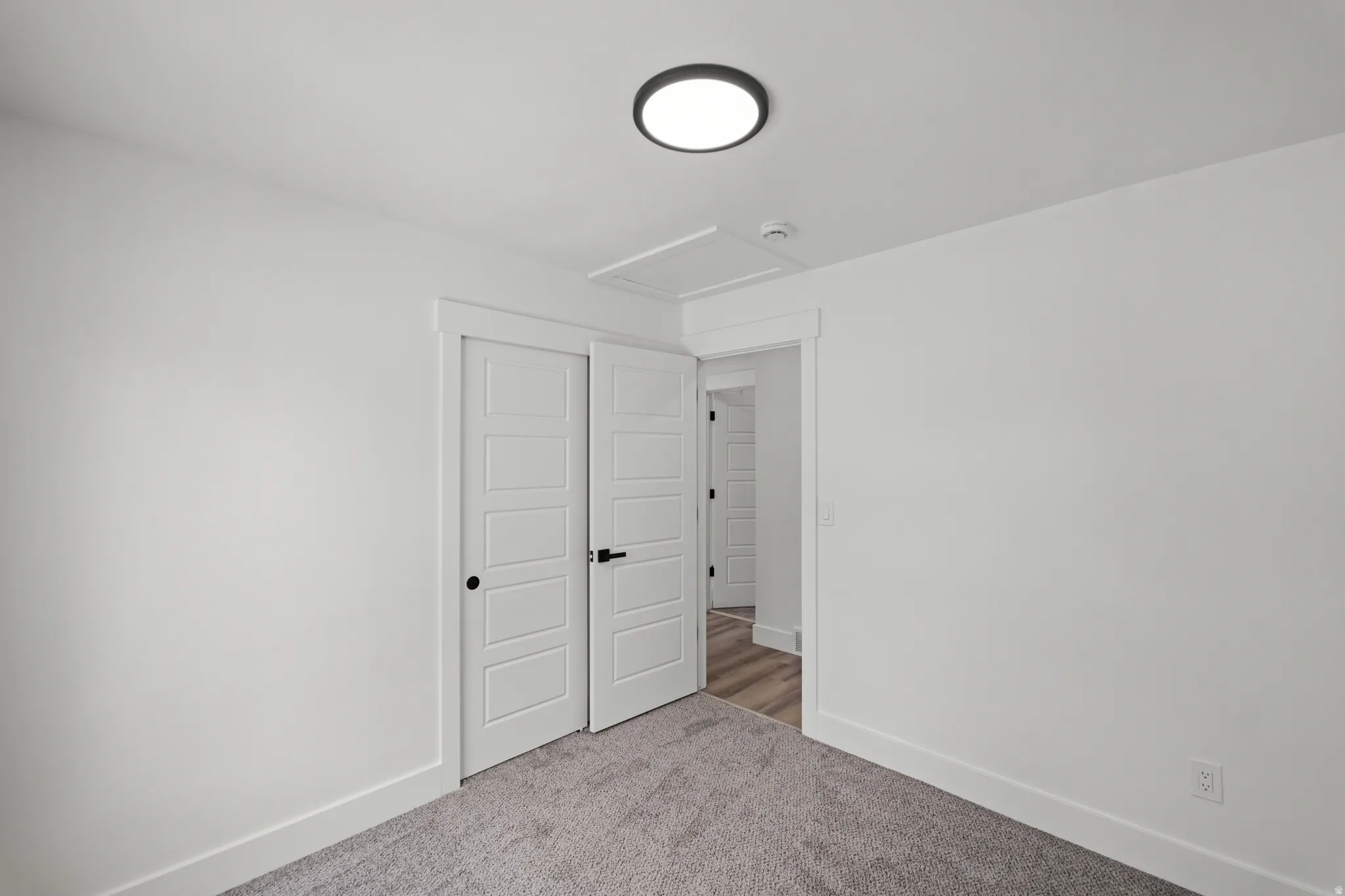 White interior walls with a flush-mount ceiling light