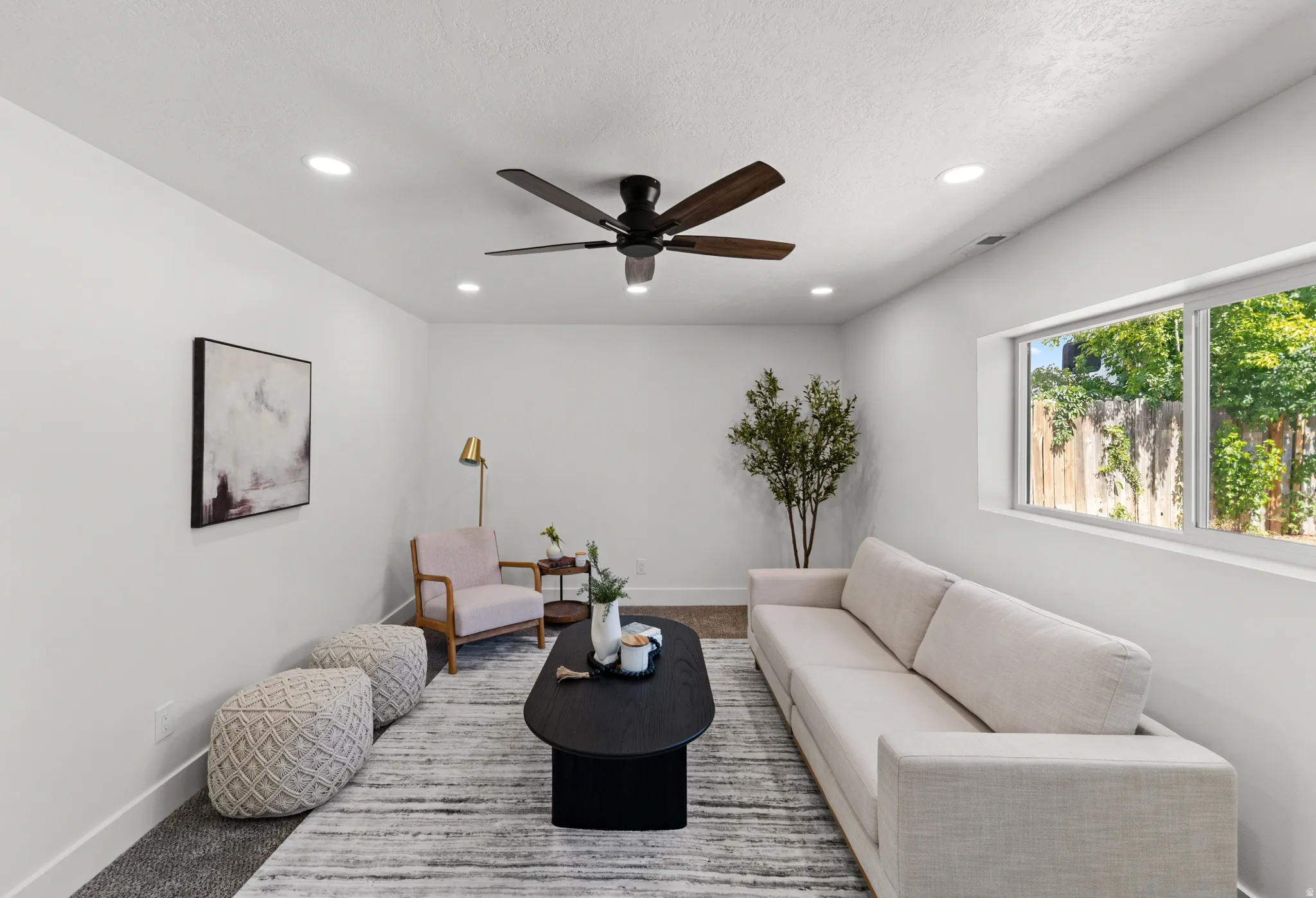 Recessed lighting, ceiling fan, large window, and light-colored walls