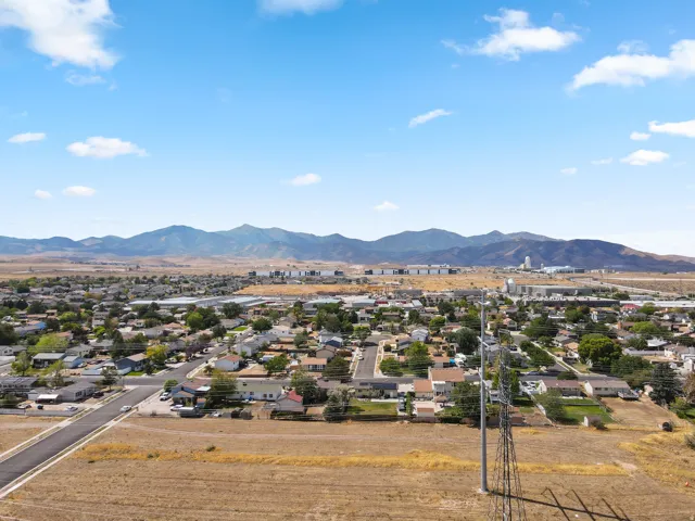Expansive residential area with a mountain backdrop, featuring a clear sky and distant commercial structures