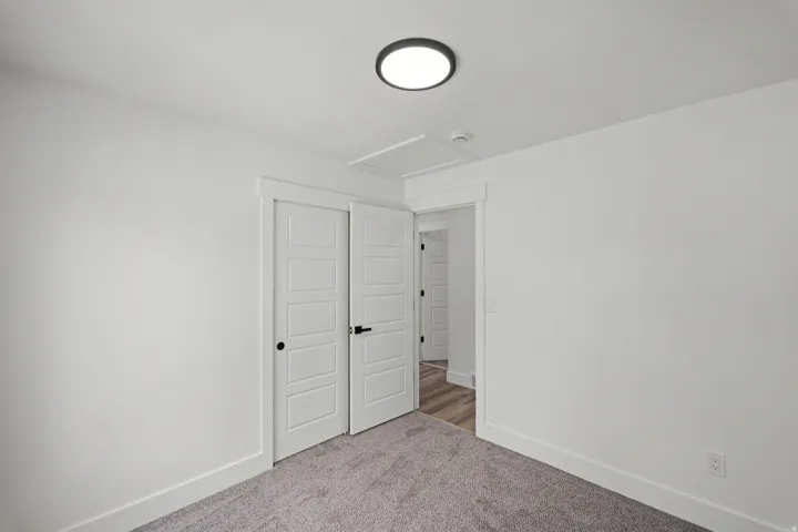 White interior walls with a flush-mount ceiling light