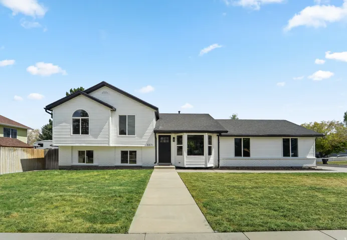Two-story exterior with white siding and dark trim, featuring a prominent arched window