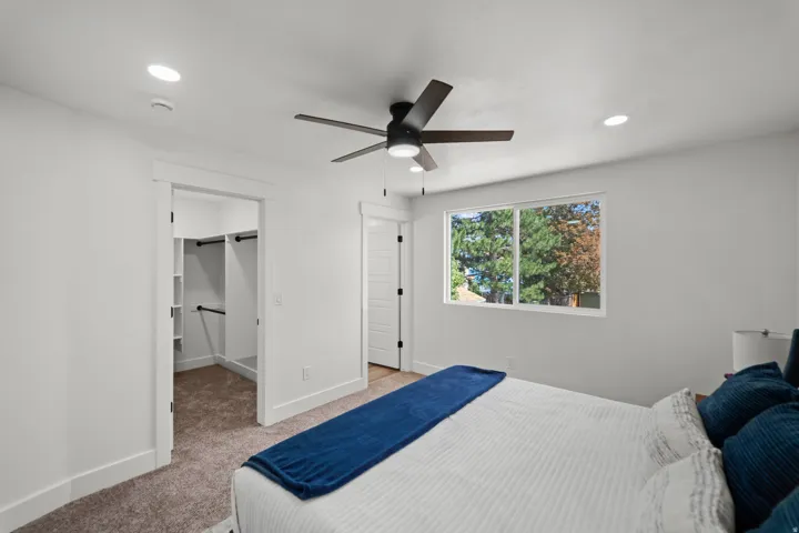 Recessed lighting, ceiling fan, carpeting, built-in closet shelving, and a bright window
