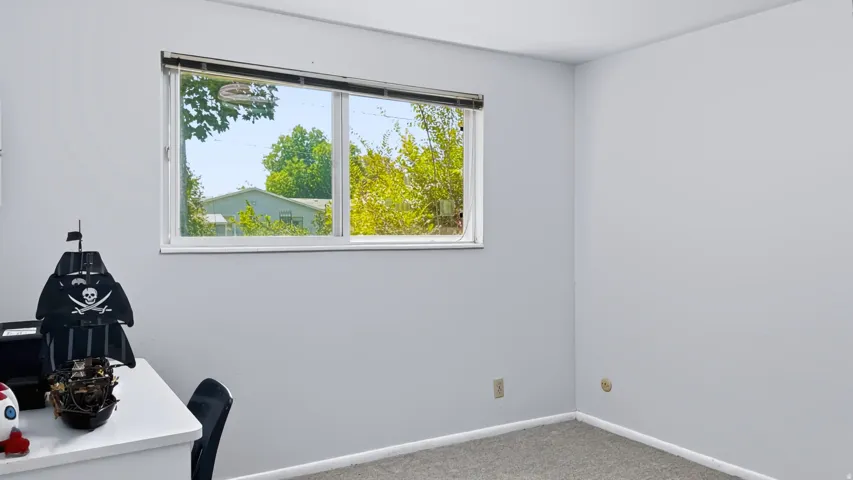 Neutral wall paint with carpet flooring and a double-pane window