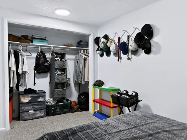 Spacious bedroom with built-in closet featuring shelving, hanging rods, and storage organizers