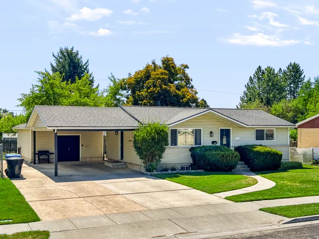 Single-story residence featuring light-colored siding and a covered carport