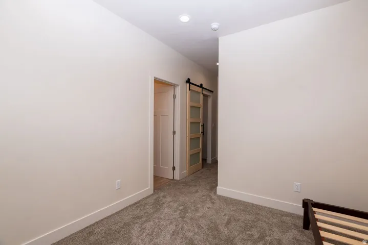 Neutral wall paint, recessed lighting, and carpeted flooring