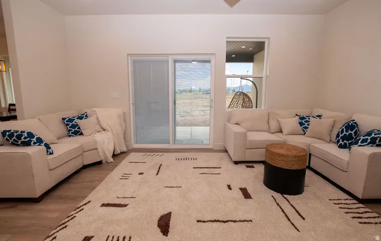 Neutral wall tones, wood-finish flooring, and a sliding glass door for outdoor access