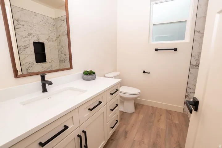 White vanity with black hardware, integrated rectangular sink, and matte black faucet