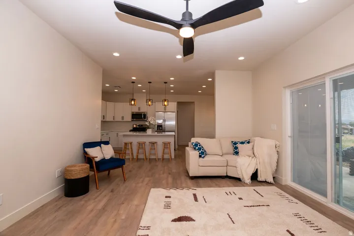 Open-concept living area featuring wood-finish flooring, recessed lighting, and a contemporary ceiling fan
