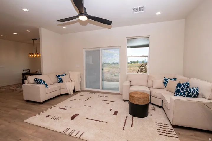 Recessed lighting, wood-finish flooring, and a modern ceiling fan with integrated lighting