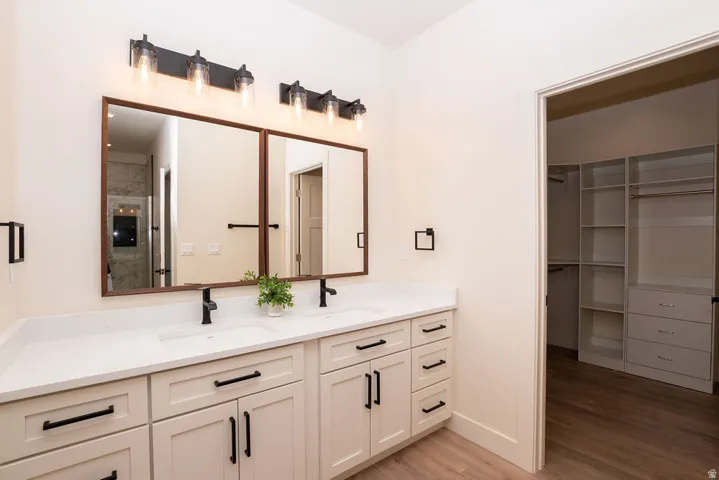 Dual vanity with white shaker-style cabinetry, white countertops, and matte black fixtures