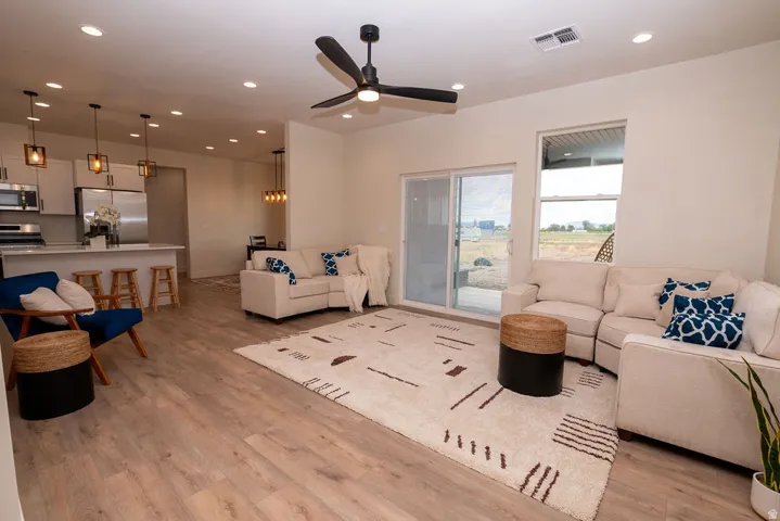Open-concept living space featuring wood-finish flooring, recessed lighting, and a modern ceiling fan