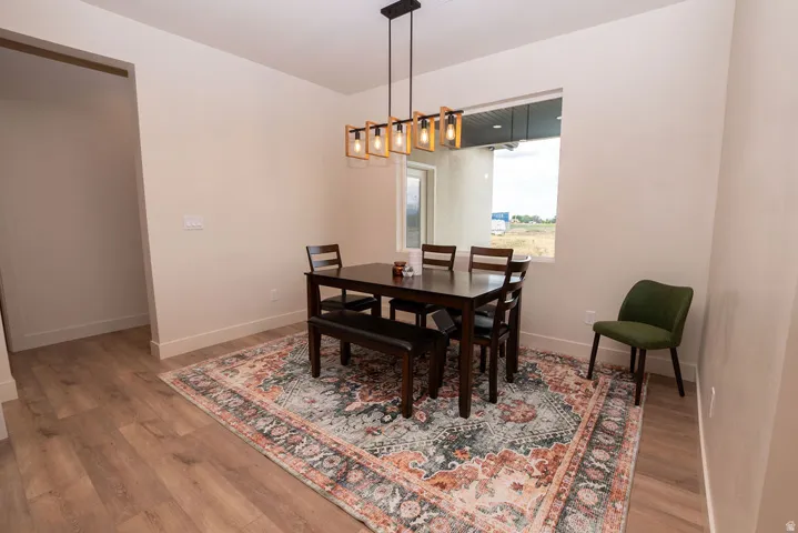 Recessed window with exterior outlook, wood-finish flooring, and a modern linear chandelier
