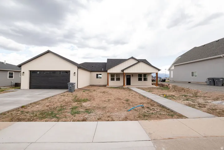 Contemporary single-story residence with a covered entry, board and batten accents, and a dark garage door