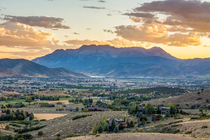 Expansive mountain scenery with a distant town and water body
