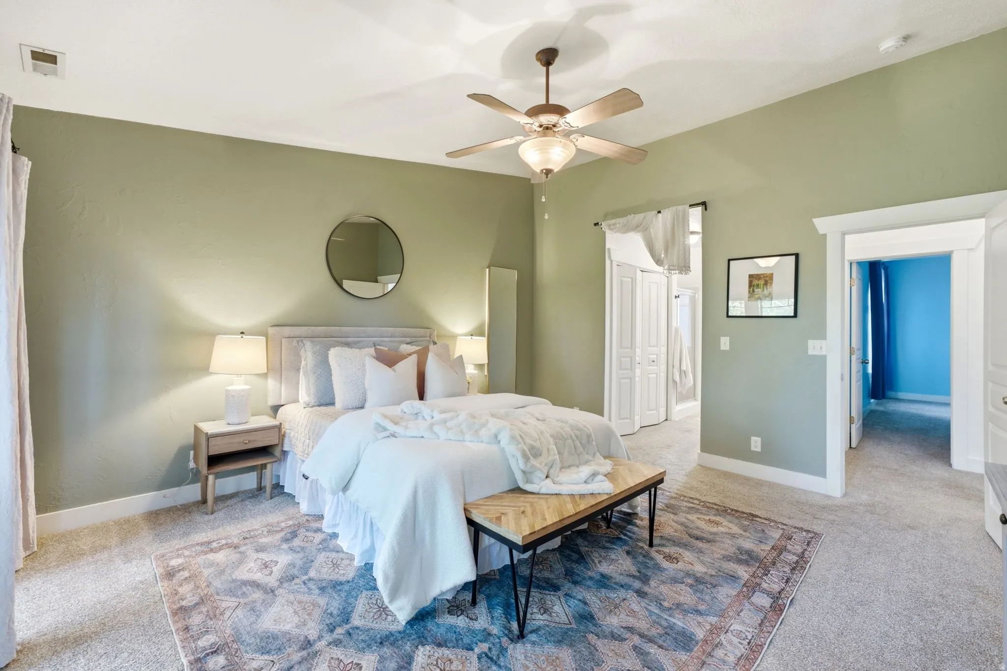 High ceilings featuring a ceiling fan, carpeted flooring, and light green painted walls