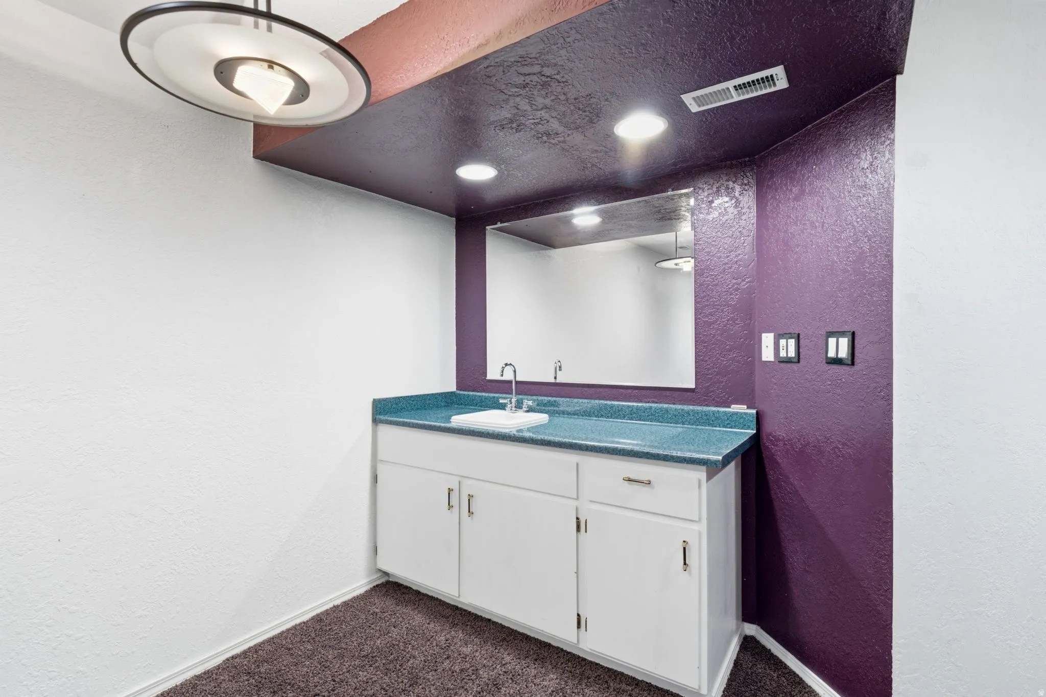 Wet bar featuring a rectangular sink, white cabinetry, and a countertop