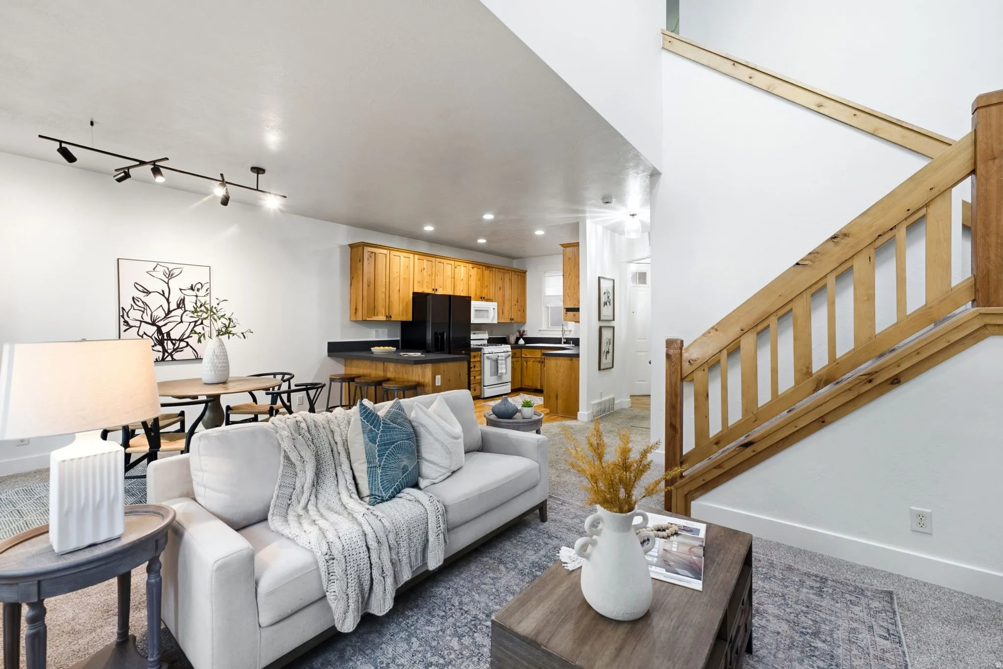 Open-concept main living area with a wood-finish staircase
